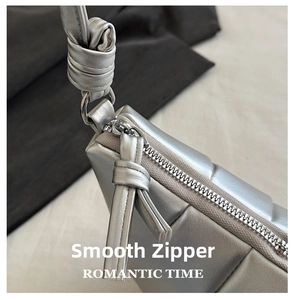 Detail of silver quilted crescent bag with smooth zipper and knotted leather puller