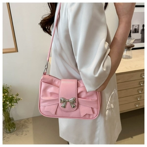 Detailed close-up of a pink bow shoulder bag featuring a silver metal buckle and soft PU leather