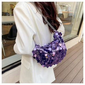 Close-up of purple sequin crescent shoulder bag with silver metal chain on a white blazer