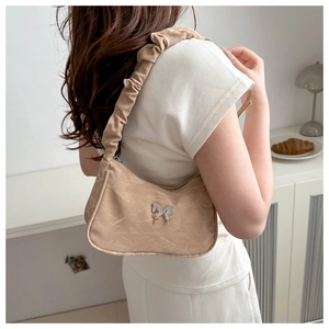 Detail of light coffee hobo bag featuring silver butterfly buckle and ruched shoulder strap