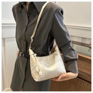 Detail of satin shoulder bag with traditional Chinese floral embroidery and bead tassel