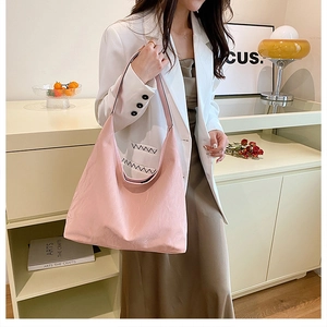 Detail of the soft pleated light pink tote bag with integrated shoulder strap