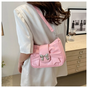 Detail of pink bow shoulder bag with silver metallic buckle on textured leather