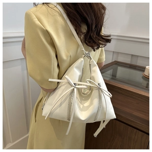 Détail du sac à dos convertible en cuir PU crème avec fermetures éclair à nœud sur modèle