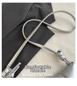 Detail of silver metallic textured crossbody bag with stylish handcrafted knotted strap detail