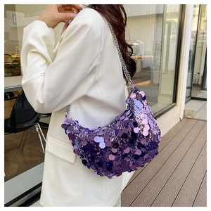 Detail of purple sequin crescent bag with silver chain strap on a white blazer