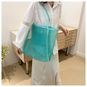 Detail of mint green mesh tote bag with durable nylon handles and breathable texture