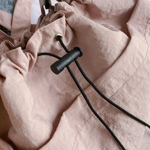 Pink nylon tote bag with adjustable black drawstring closure and silver metal eyelet