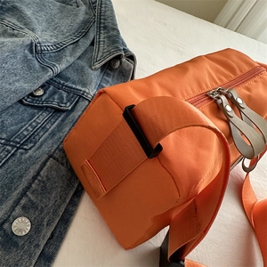 Large bright orange nylon crossbody bag for couples with a sporty waterproof design