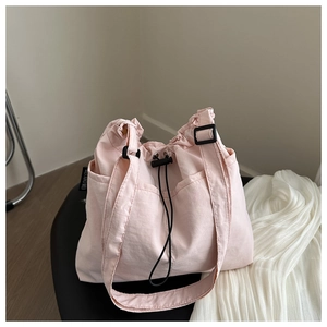 Detail of the pink drawstring tote bag showing durable fabric and adjustable black straps