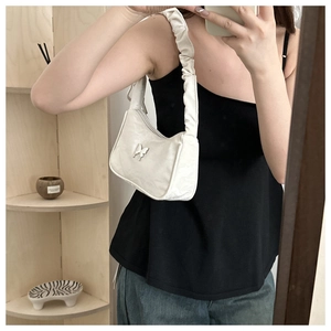 Détail du sac hobo blanc avec bandoulière froncée et boucle papillon en métal argenté