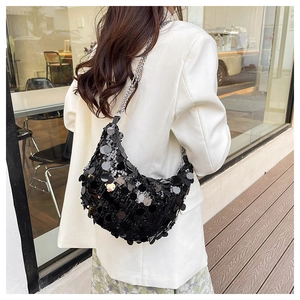 Detail of a sparkling black sequin shoulder bag with silver chain strap on model
