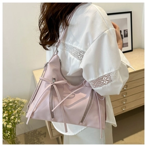 Détail du sac en nylon rose clair style ballet avec rubans décoratifs et zips