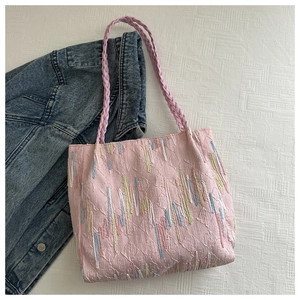Pink canvas tote bag with embossed letter patterns and colorful vertical embroidery stripes