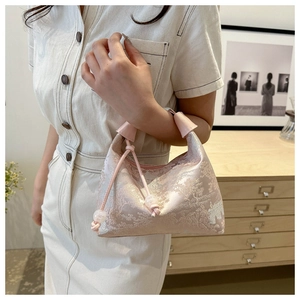 Close-up of pink jacquard fabric handbag with tree texture and drawstring closure detail
