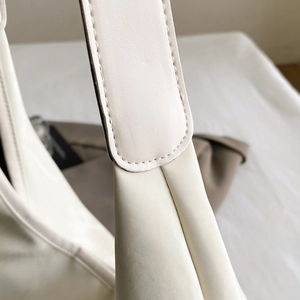Premium cream white leather tote bag with wide shoulder strap and refined stitching detail