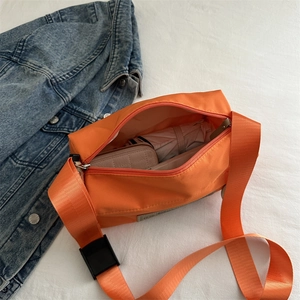 Orange waterproof crossbody bag with large capacity showing folded umbrella and wallet inside