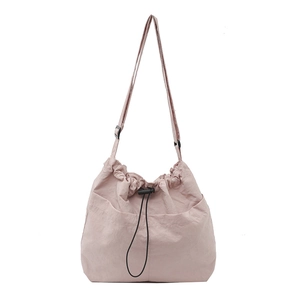 Minimalist light pink drawstring tote bag with adjustable strap and front pockets