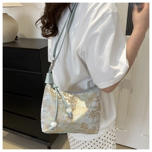Detail of light blue jacquard shoulder bag with gold landscape print and pearl charms