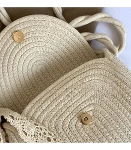 Detailed close-up of golden magnetic metal buckle on a woven straw shoulder bag