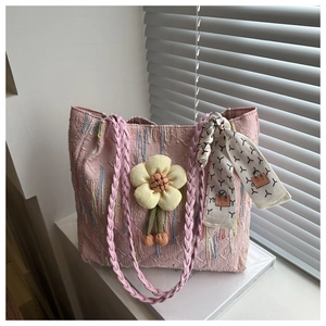 Detailed texture of pink canvas tote bag with floral charm and printed silk scarf accessory
