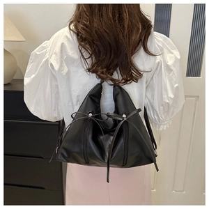 Détail du sac hobo en cuir noir souple avec grand nœud et fermetures éclair verticales