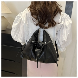 Vue arrière du sac à bandoulière noir en demi-lune avec nœuds et zips verticaux