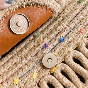 Handcrafted straw tote bag with brown leather trim and colorful embroidery detail