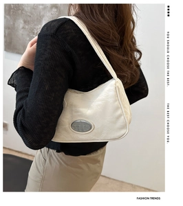 Detail of white nylon hobo bag with cloud-like pleated texture and silver metal logo