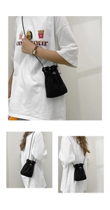 Detail of a black drawstring bucket bag showing compact design and woven fabric texture
