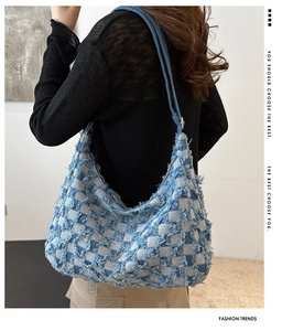 Vue latérale du sac hobo en jean à damier avec bords effilochés et large bandoulière