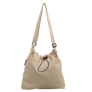 Minimalist beige drawstring tote bag with adjustable shoulder strap and side pockets