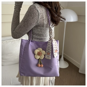 Detail of lavender nylon tote bag featuring 3D floral accent and printed silk scarf