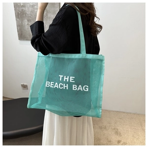 Dettaglio della borsa da spiaggia in rete di nylon verde menta con lettere stampate