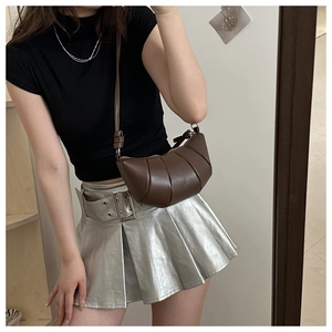 Detail of dark brown dumpling bag featuring pleated leather texture and slim shoulder strap