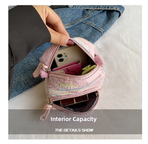 Detail showing internal capacity of the pink woven crossbody bag with dual compartments