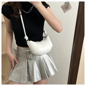 White leather croissant bag with pleated stitching details worn by a model