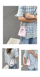 Pink drawstring mini crossbody phone bag shown from multiple angles in a street setting
