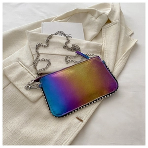 Detail of metallic gradient envelope bag with silver rivets on a beige blazer background