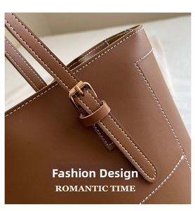 Détails macro d'un cabas en cuir marron avec surpiqûres blanches et boucle en métal doré