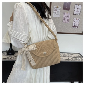 Detailed texture of straw woven bucket bag with pearl buckle and lace ribbon detail