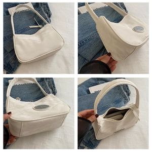 Detail of white wrinkled faux leather texture and interior space of this armpit bag
