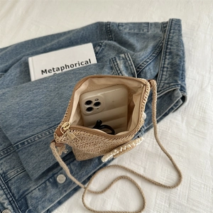 Handwoven straw crossbody bag with pearl accents and zip closure for summer fashion