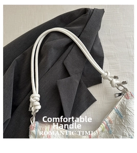 Detail of white textured tote with colorful embroidery and unique knotted rope handle