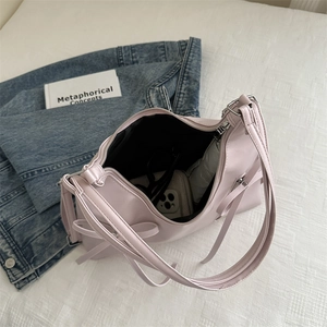 Sac hobo en cuir rose clair montrant l'intérieur spacieux avec des objets du quotidien