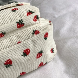 Off-white corduroy shoulder bag featuring embroidered strawberry patterns and vertical texture