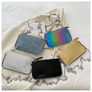 Flat lay of mini rectangular chain bags in five metallic and denim colors with beaded edges