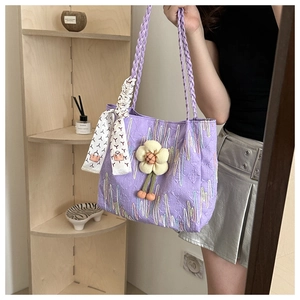 Detail of purple quilted canvas tote bag with woven handles and decorative scarf
