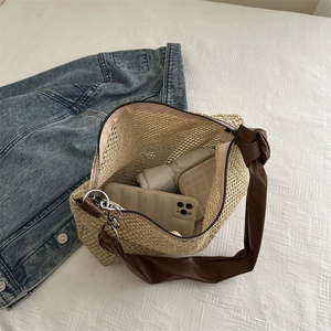 Minimalist straw tote bag with brown leather handles and chain detail showing large interior