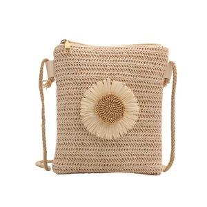 Straw square crossbody bag with large floral detail and rope strap on white background